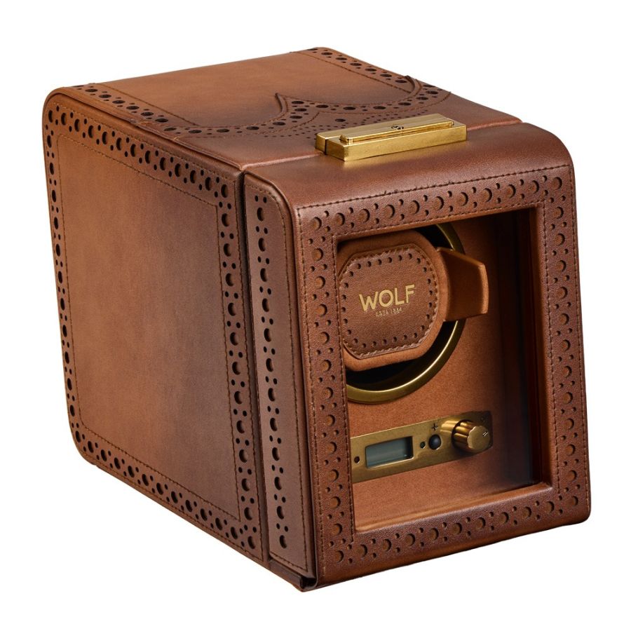 Brown leather watch winder with perforated brogue detailing, gold-tone hardware, and digital controls visible through front o
