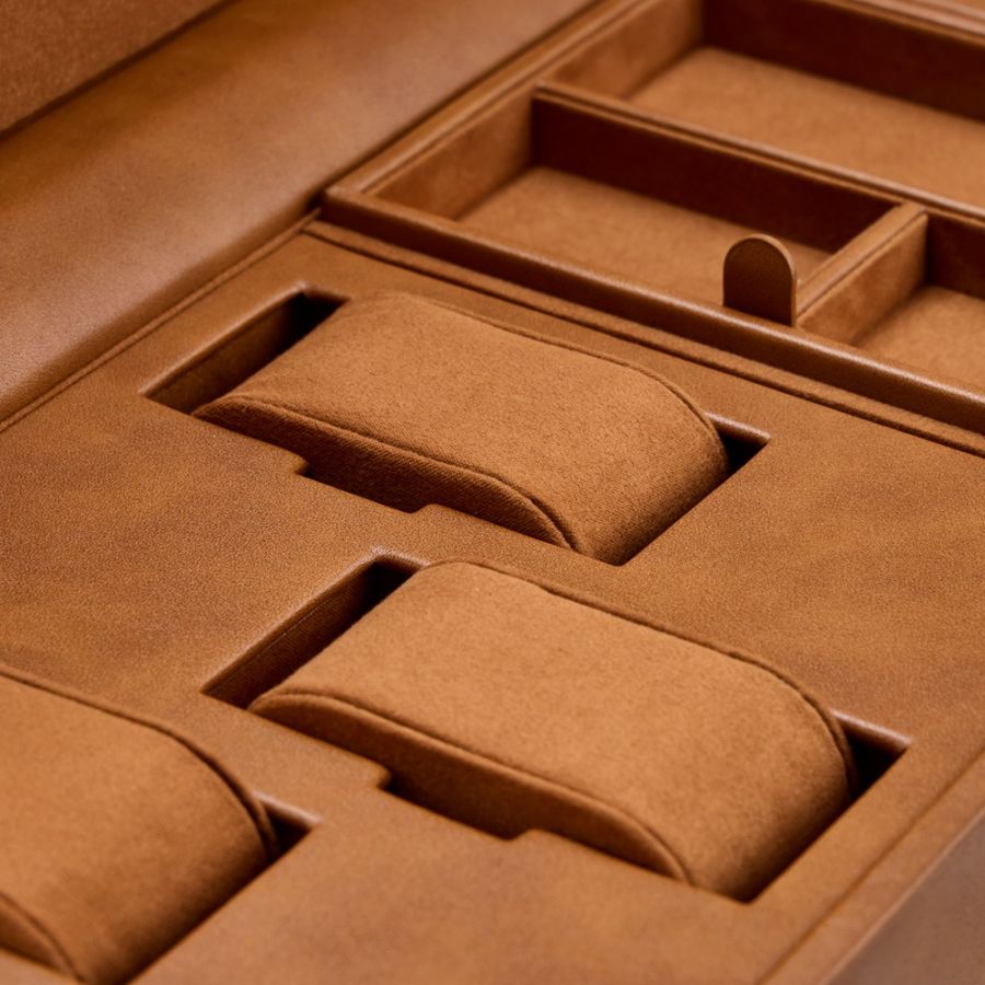 Tan leather watch winder box with three padded compartments and storage sections for jewelry or accessories.