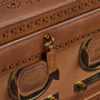 Tan leather brogue briefcase with perforated detailing, brass hardware, and multiple handles with storage compartments.