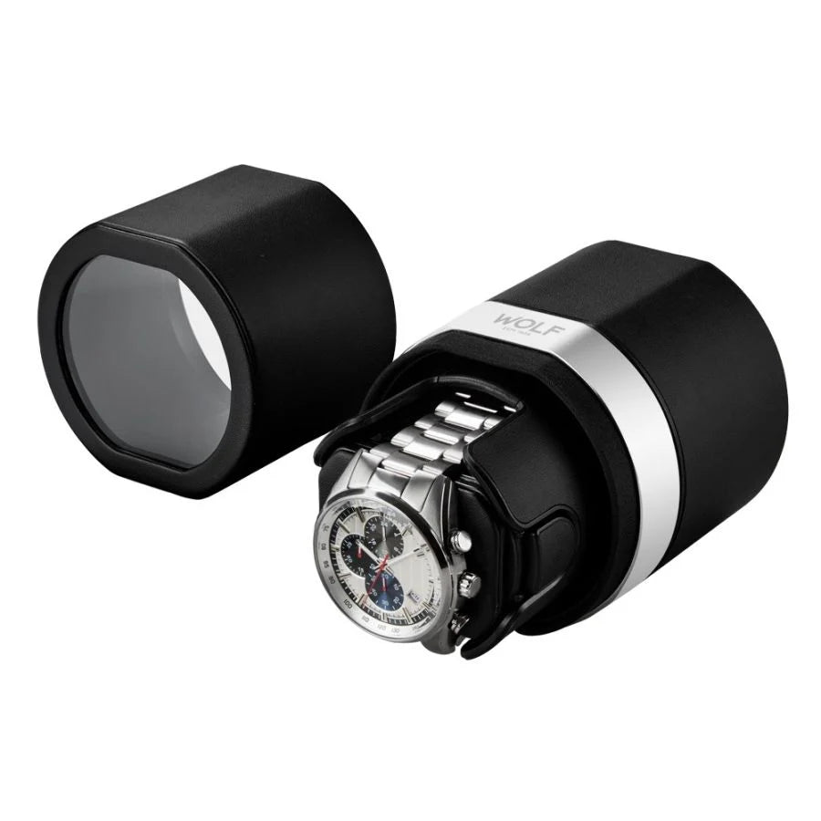 Black cylindrical watch case with white band stripe, showing chronograph watch with metal bracelet inside and separate cap.
