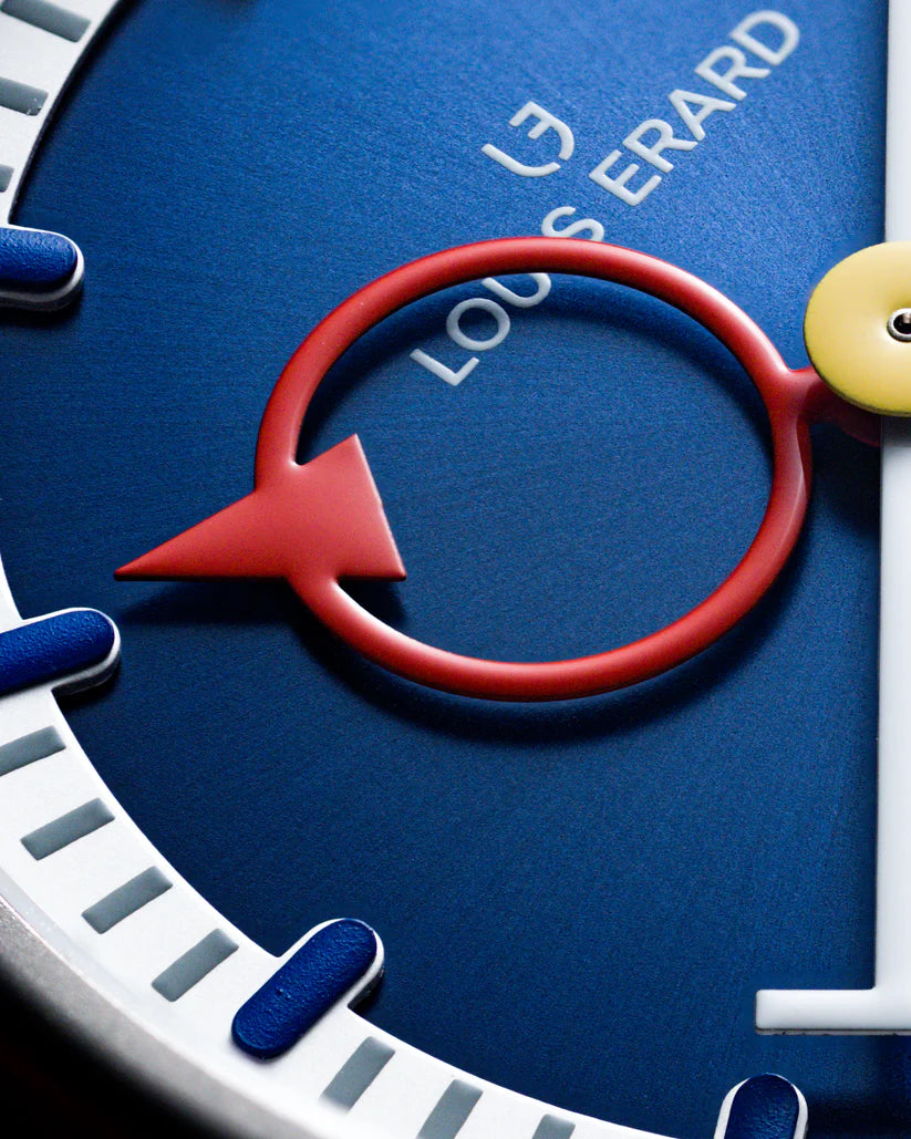 Blue watch dial with red smile-shaped hand and Louis Erard branding visible.