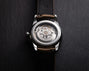 Watch with visible mechanical components on a dark background