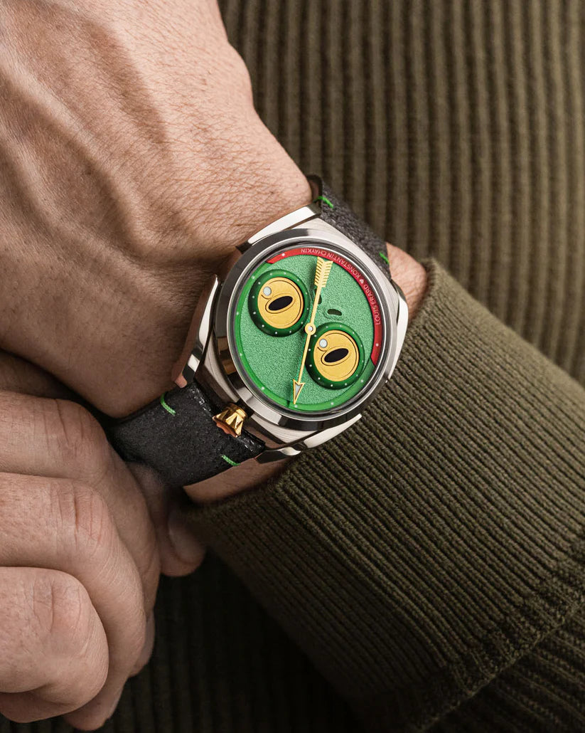 Watch with a unique green face on a wrist, wearing a brown jacket.
