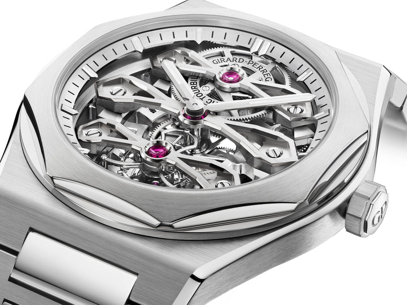 A close-up of the Girard-Perregaux Laureato Three Gold Bridges skeleton watch, highlighting its exposed gears, signature tourbillon movement, and polished stainless steel case with bracelet.