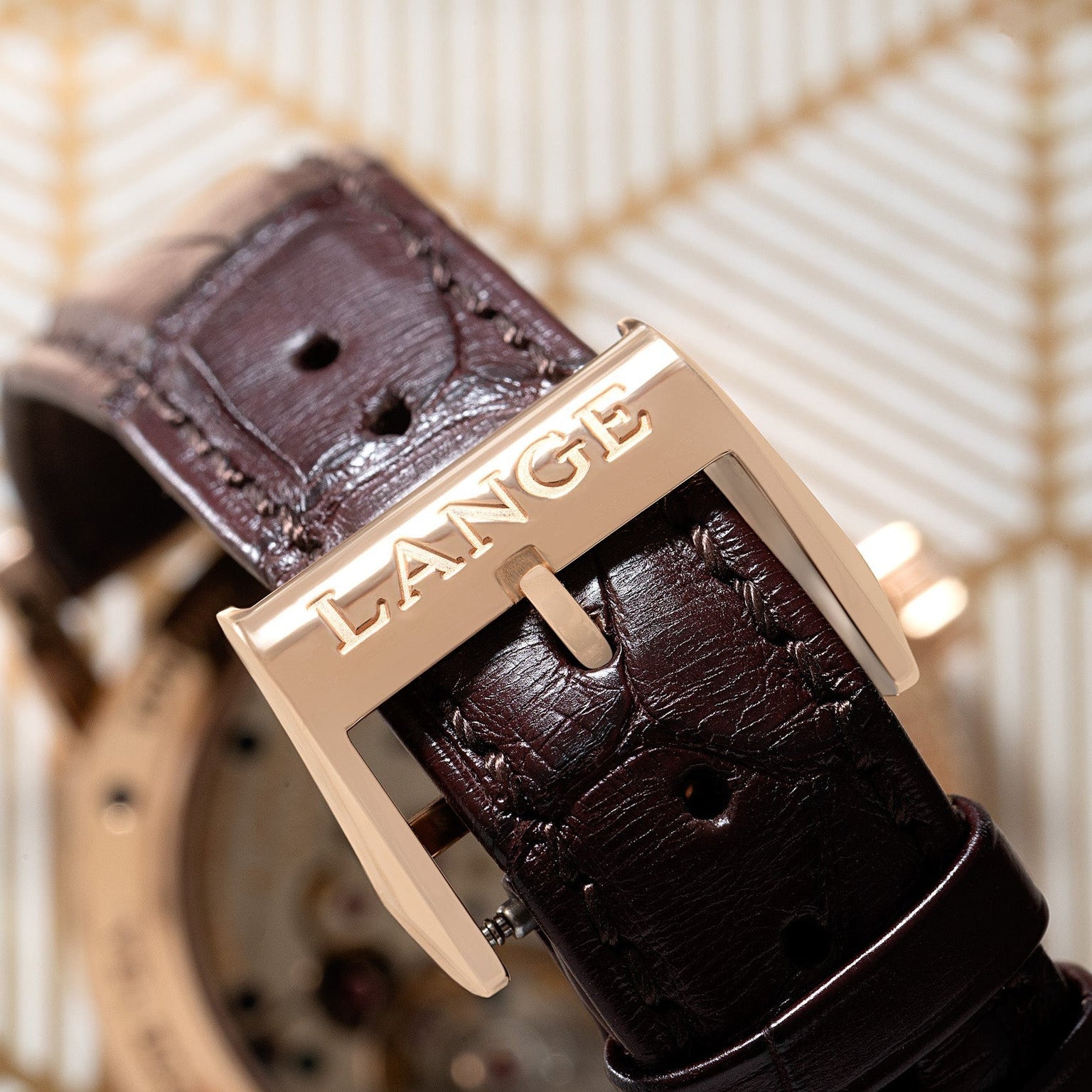 Close-up of a brown leather watch strap from Lange & Sohnes Richard Lange, featuring a gold buckle engraved with LANGE.