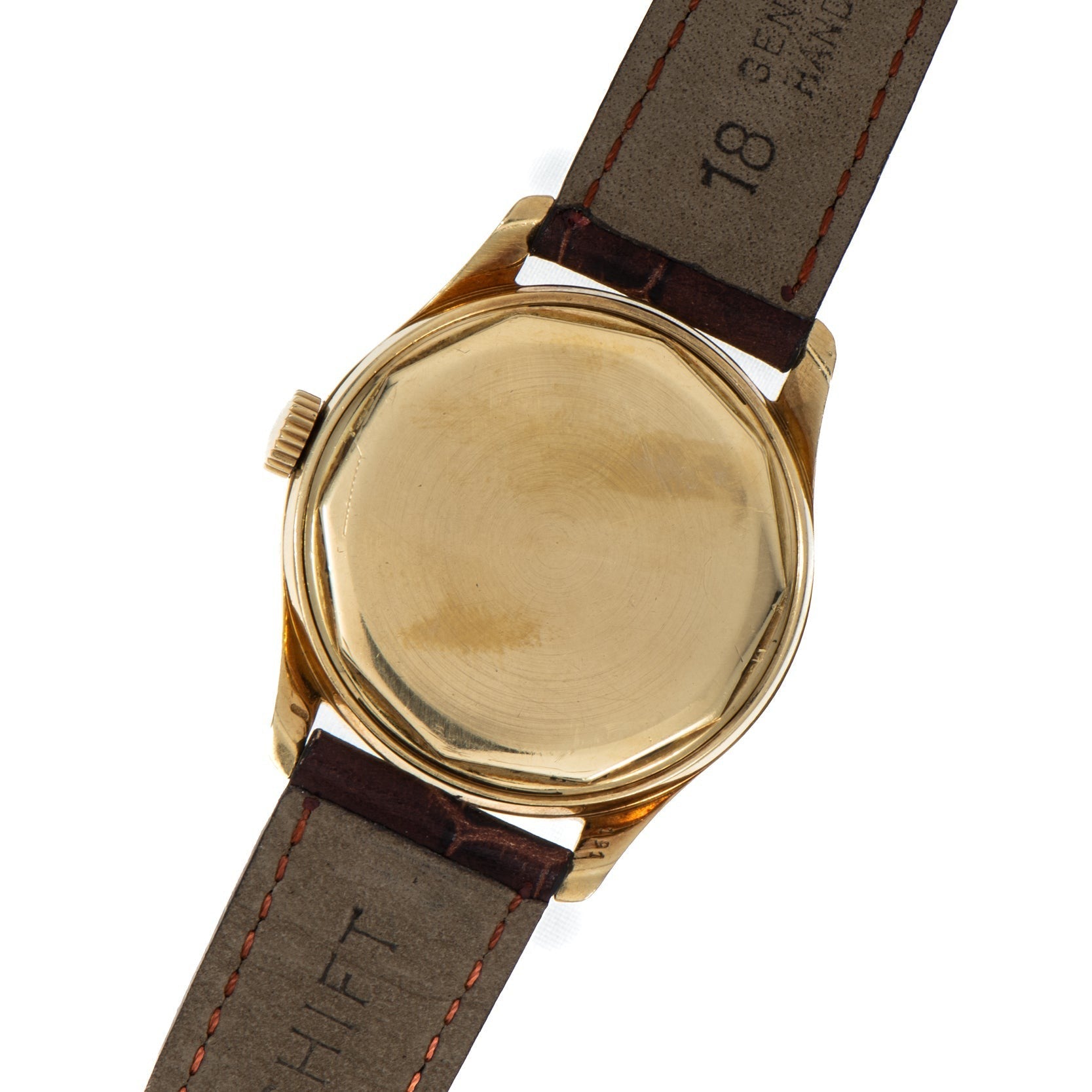 Patek Philippe Calatrava gold wristwatch with a plain, round case back and brown leather strap, shown from the back.