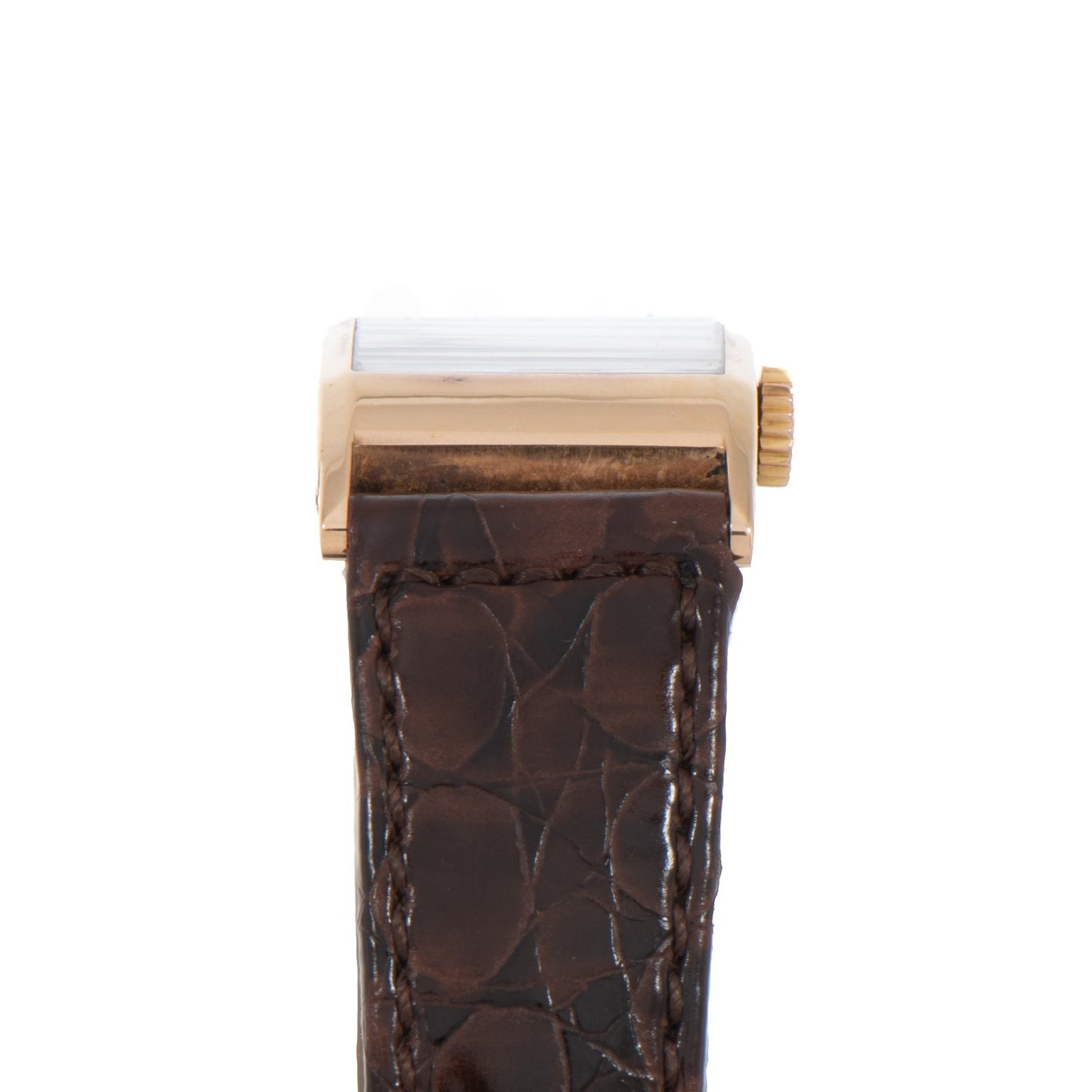 Side view of the Patek Philippe Tegolino Dress Watch featuring a gold case, brown leather strap, and textured pattern.