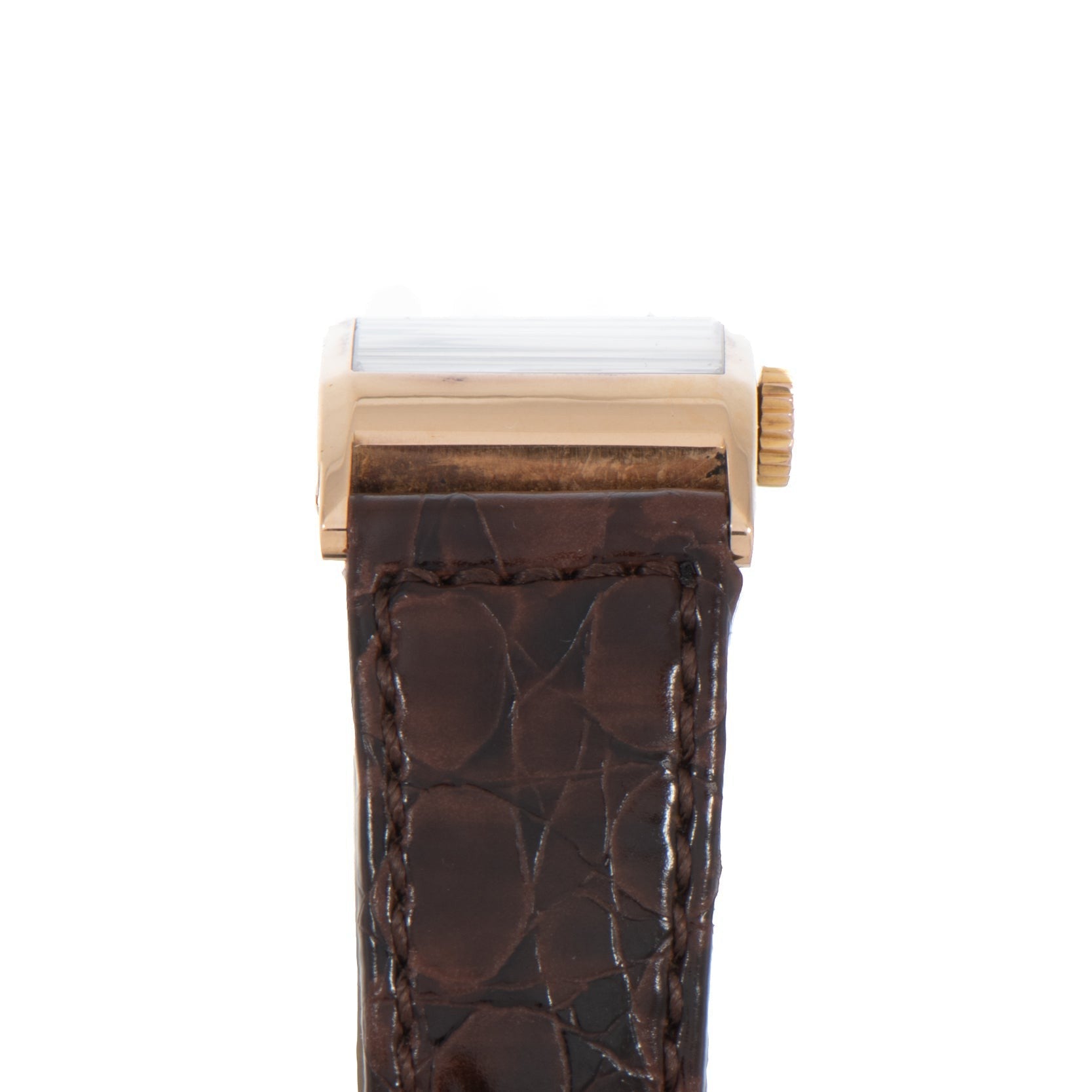 Side view of the Patek Philippe Tegolino Dress Watch featuring a gold case, brown leather strap, and textured pattern.