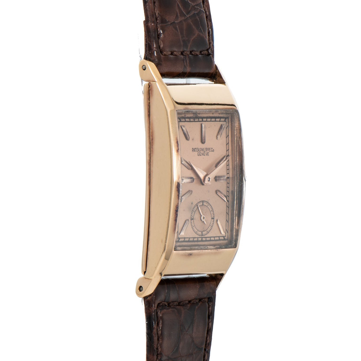 The Patek Philippe Tegolino Dress Watch features a gold rectangular case and brown leather strap, showcased from the side to highlight its elegant curved profile.