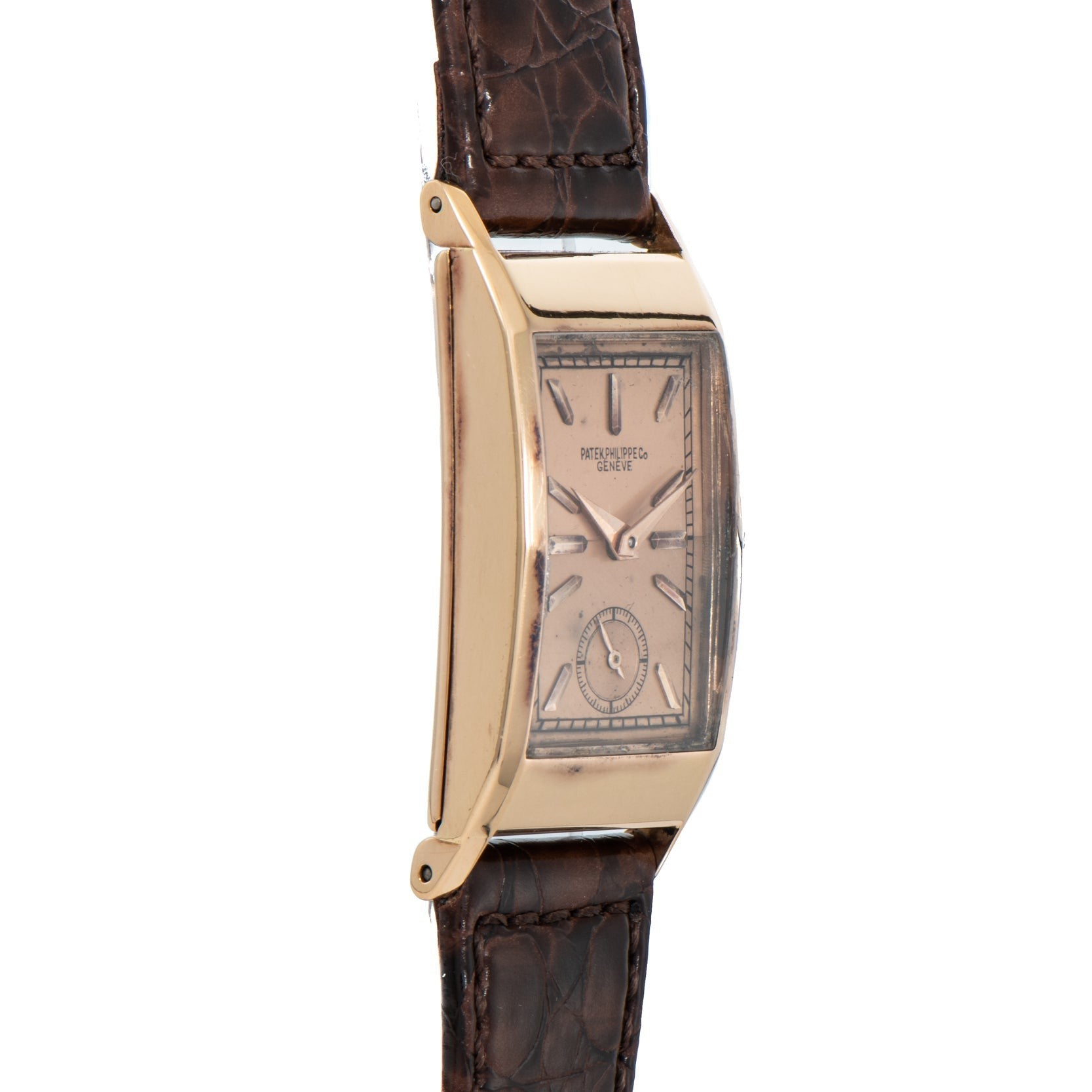 The Patek Philippe Tegolino Dress Watch features a gold rectangular case and brown leather strap, showcased from the side to highlight its elegant curved profile.