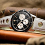 The Breitling Co-Pilot Chronograph is a vintage black and silver wristwatch featuring a white perforated leather strap.