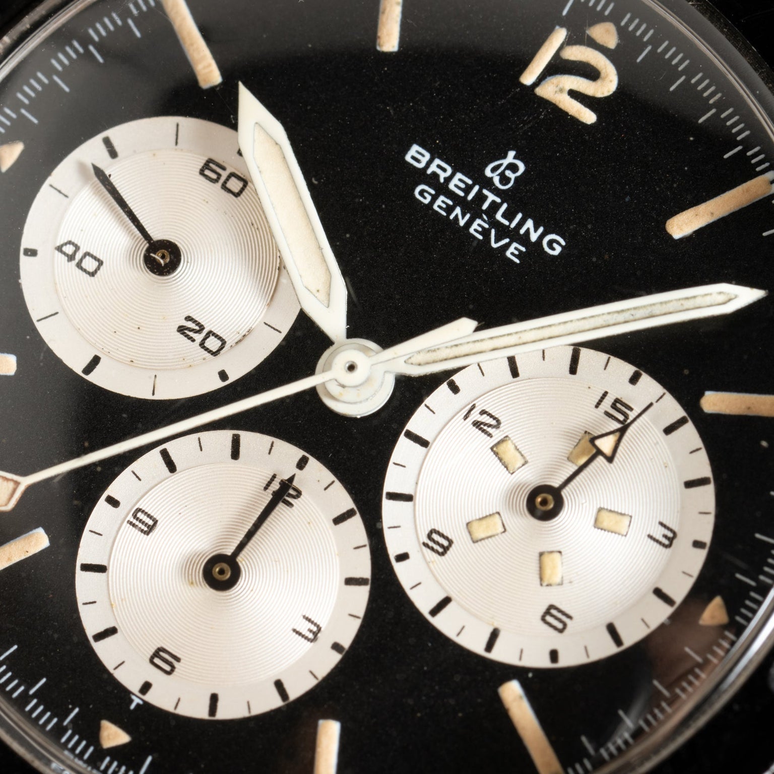 Close-up of a black Breitling Co-Pilot Chronograph watch face with three subdials and white hands.