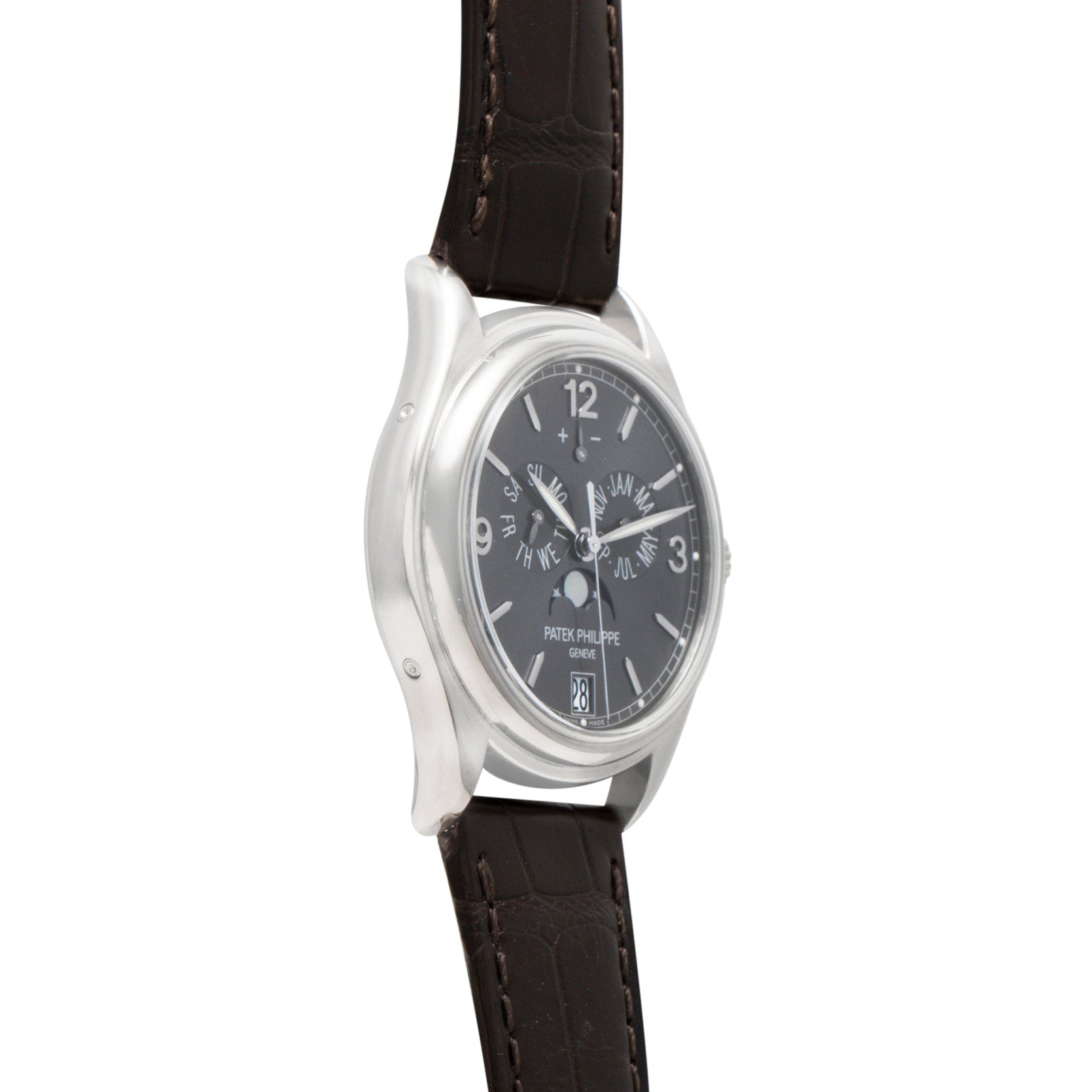 The Patek Philippe Annual Calendar Moonphase wristwatch features a black dial and brown leather strap, elegantly displayed at an angle.