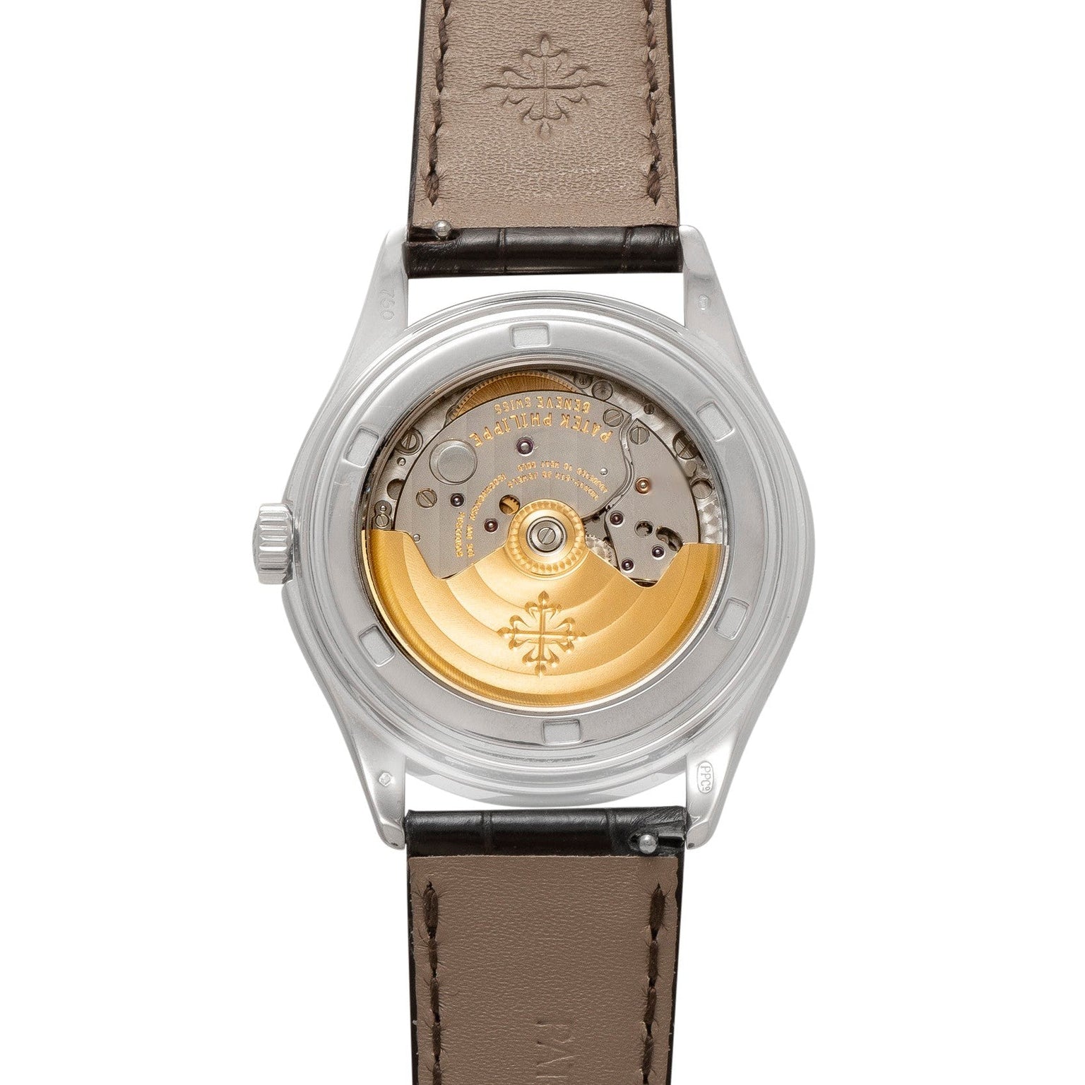 Close-up of the Patek Philippe Annual Calendar Moonphase’s transparent back, revealing its gold automatic movement and brown leather strap.