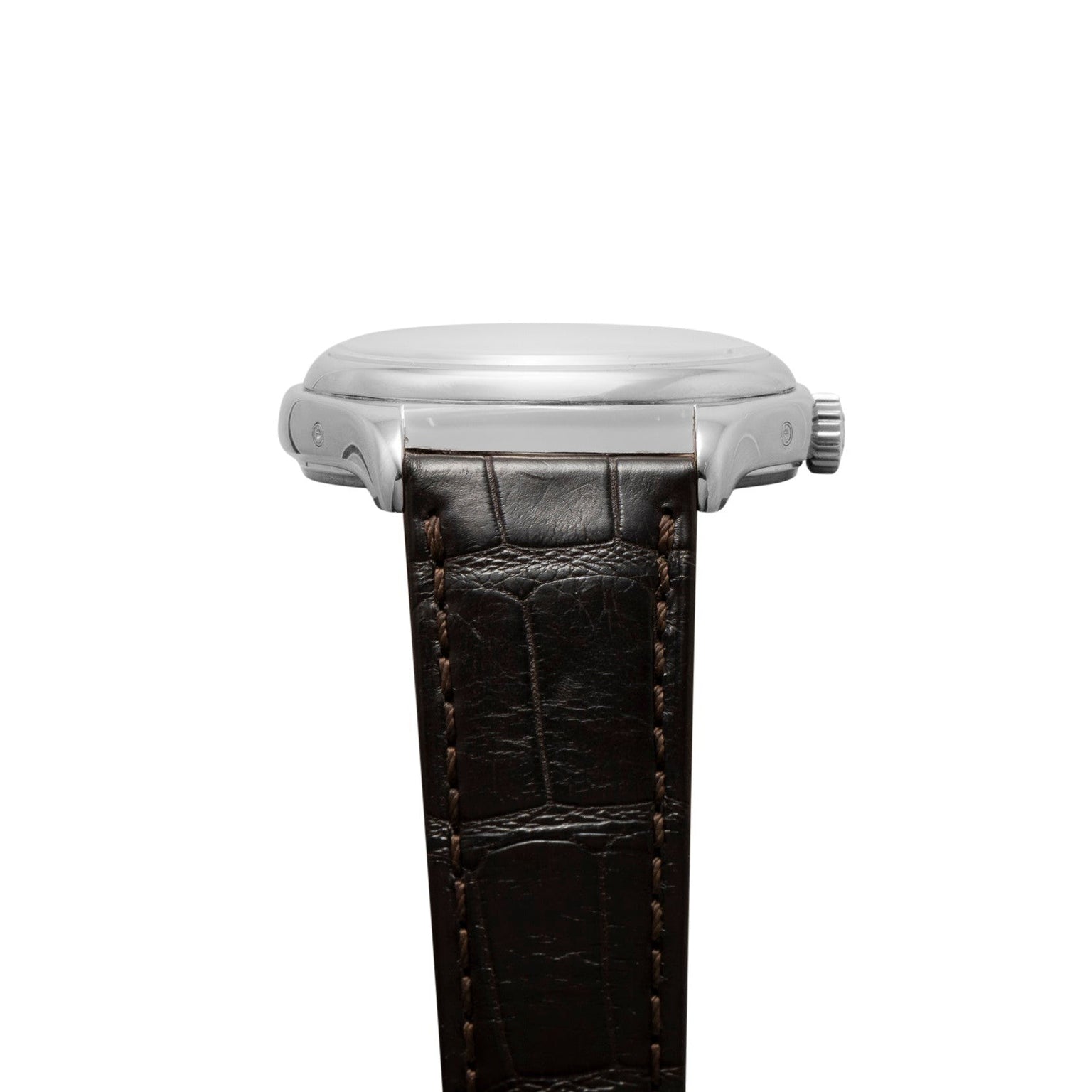 Side view of the Patek Philippe Annual Calendar Moonphase wristwatch in silver with a brown leather strap and visible stitching.