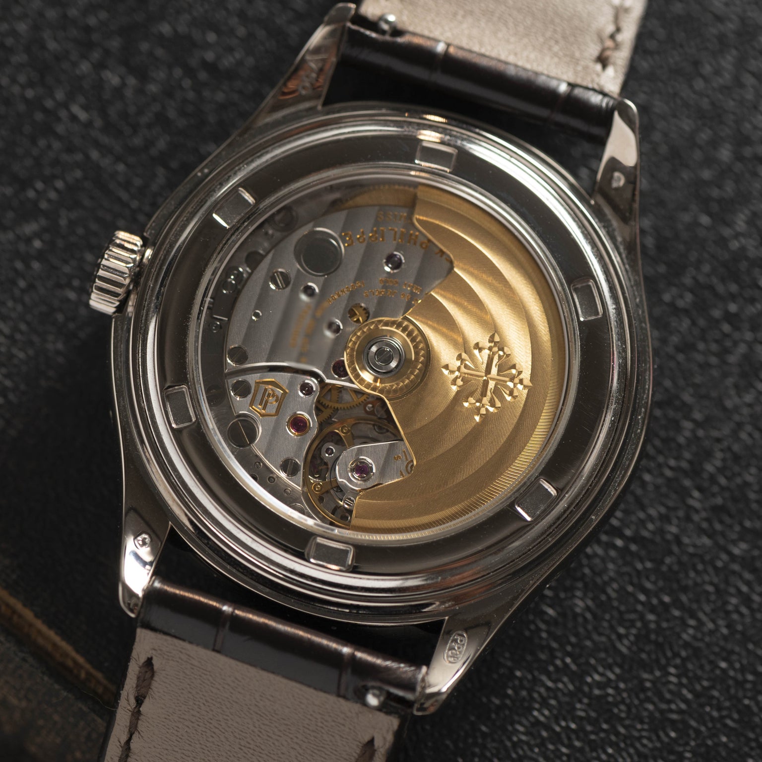 Close-up of the Patek Philippe Annual Calendar Moonphase’s transparent case back, displaying its intricate mechanical movement and gold rotor.