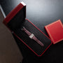 A Cartier Tank Divan wristwatch in brown leather, placed in a red gift box on a black table.