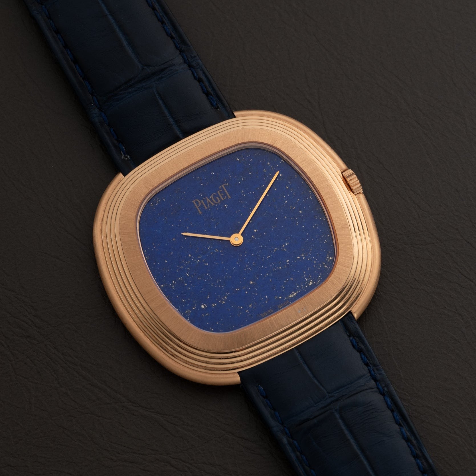 Piaget Black Tie Andy Warhol wristwatch featuring a blue speckled face and dark blue leather strap, displayed on a black surface.