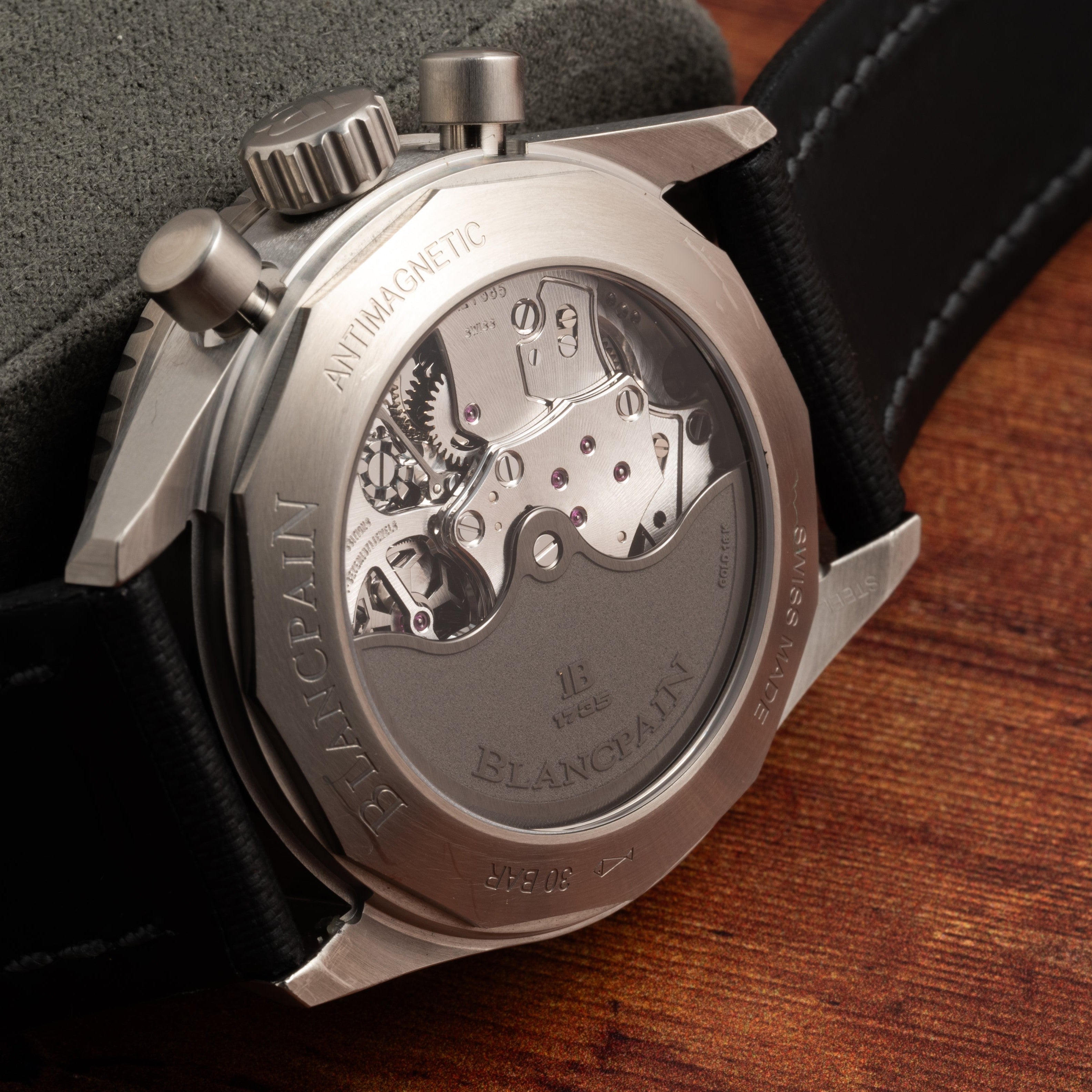 Close-up of the Blancpain Fifty Fathoms Bathyscaphe Chronographe Flyback watch back, revealing its inner mechanical movement and ANTIMAGNETIC engraved on the metal.