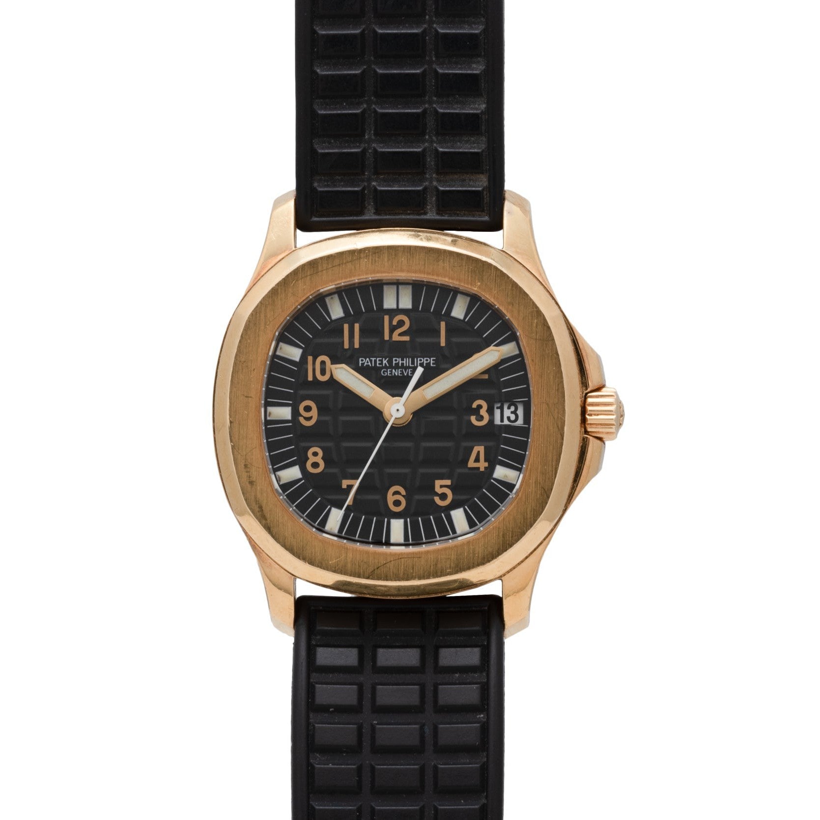 A Patek Philippe Aquanaut wristwatch in gold with a black dial, black textured rubber strap, and date display.