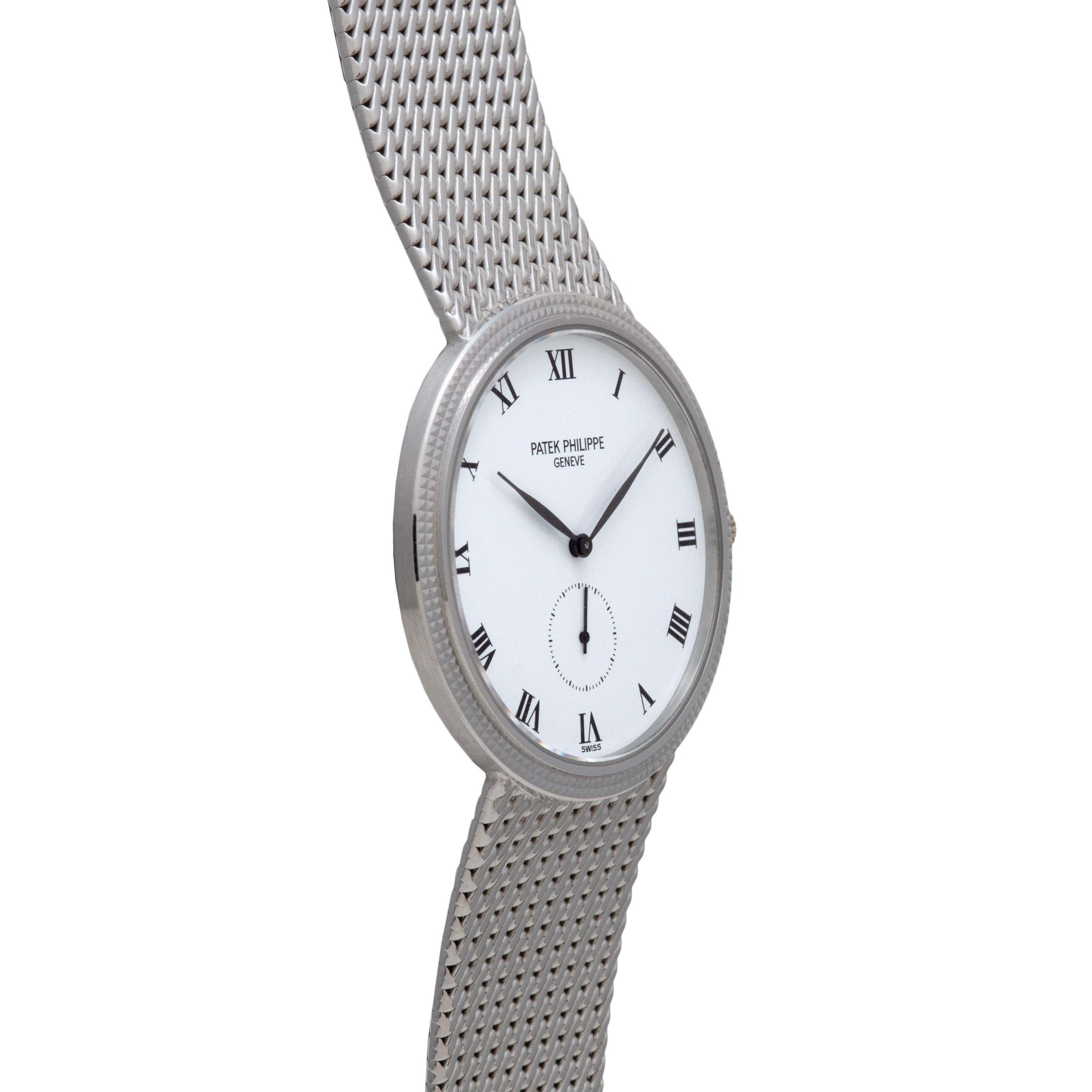 The Patek Philippe Calatrava features a silver mesh bracelet, white dial with Roman numerals, and a small seconds subdial at six oclock.