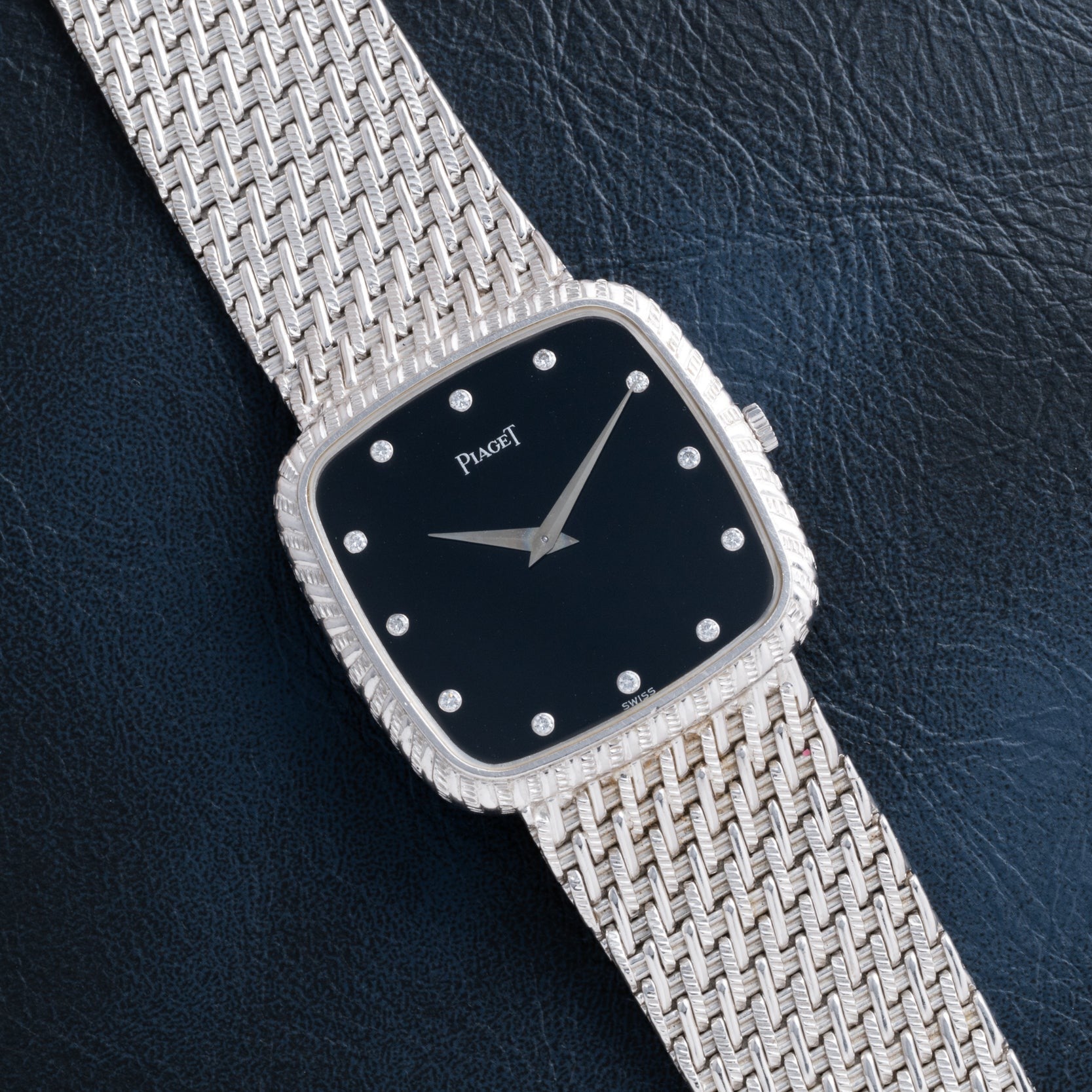 A Piaget Onyx Dial White Gold Dress Watch featuring an onyx face and diamond hour markers, set on a white gold textured band.