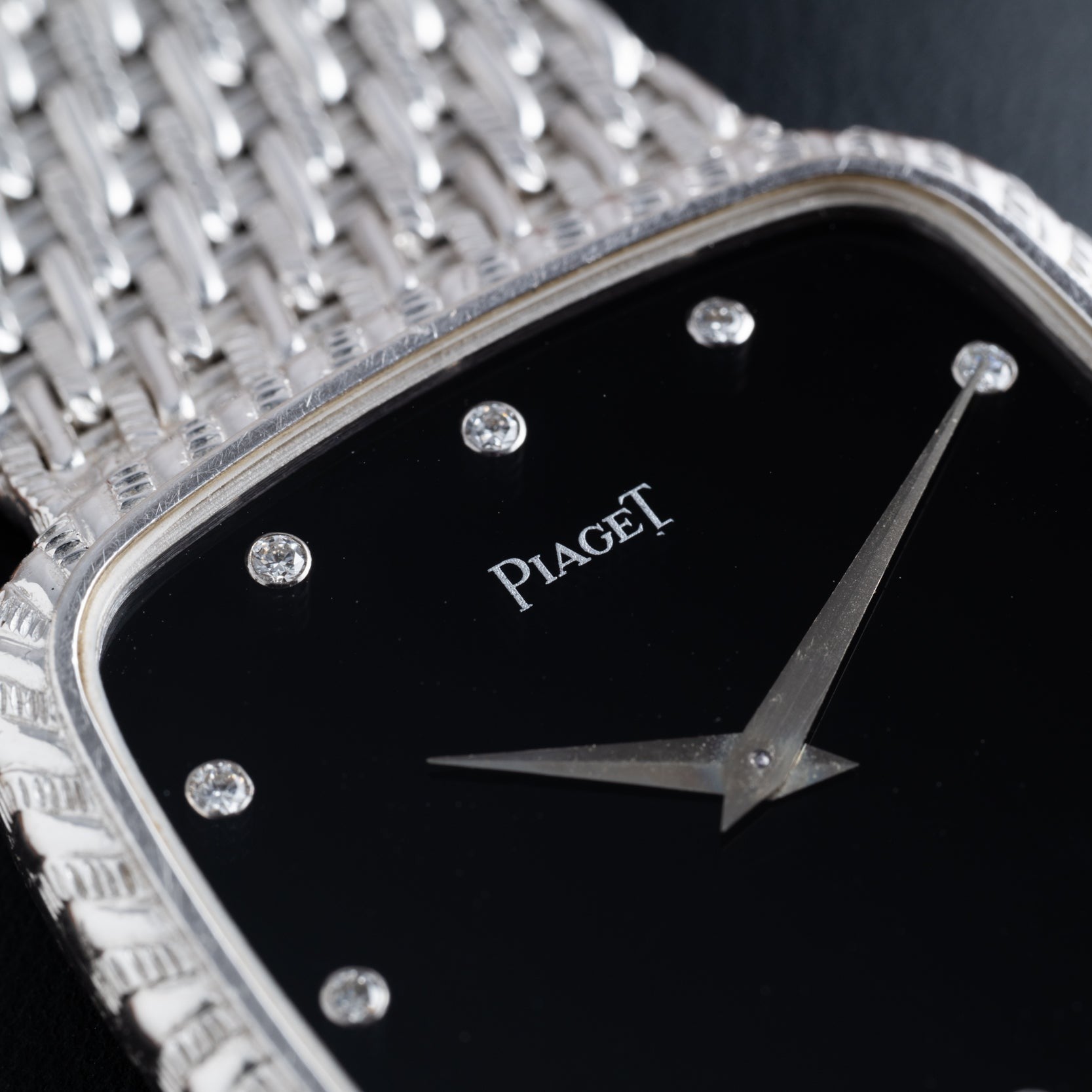 Close-up of the Piaget Onyx Dial White Gold Dress Watch featuring a black onyx face, diamond hour markers, and a textured silver bracelet.