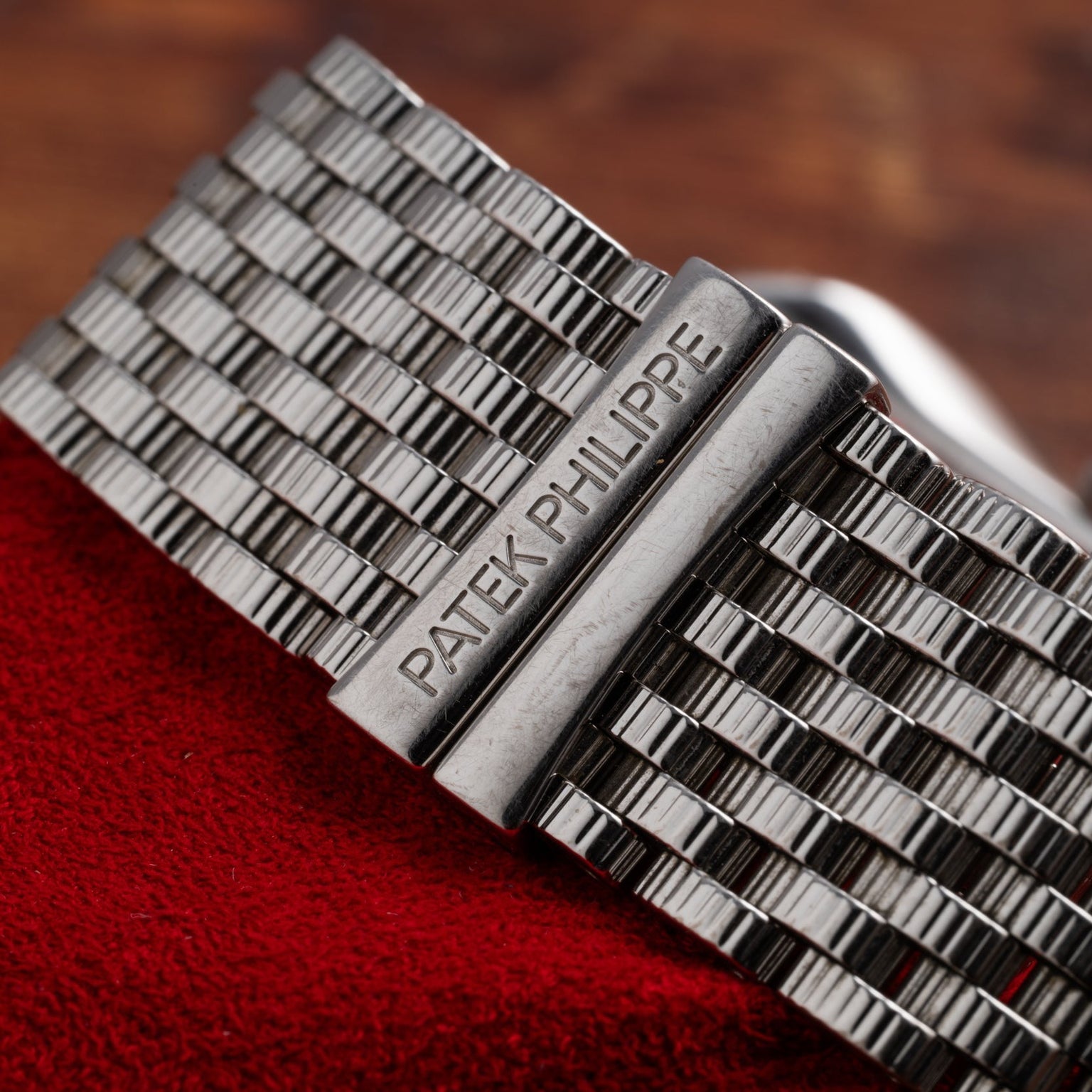 Close-up of a Patek Philippe Gondolo Ladies silver watch bracelet resting on red fabric.