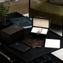 A Patek Philippe Gondolo Ladies watch displayed in an open box, surrounded by booklets and papers on a black table.