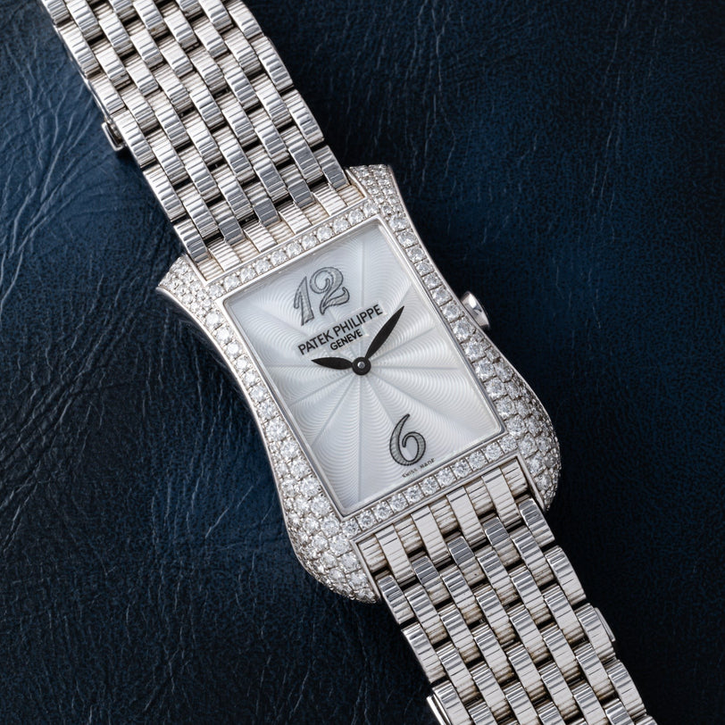 The Patek Philippe Gondolo Ladies watch features diamond accents and a silver bracelet set against dark textured leather.