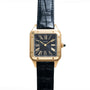 The Cartier Santos Dumont watch features a square black face with Roman numerals and a black leather strap, shown on a white background.