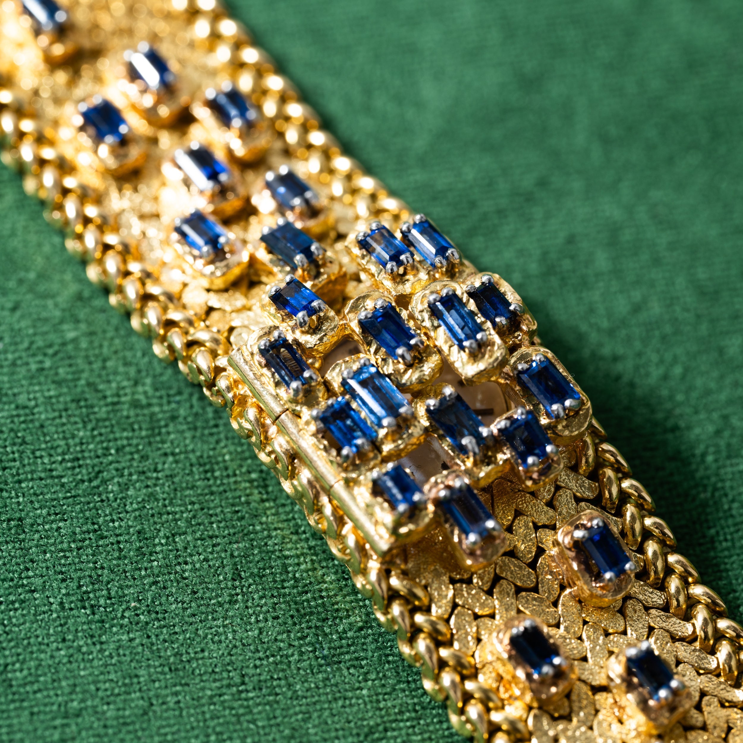 Patek Philippe Yellow Gold Integrated Dress Watch displayed on a green textured fabric background.