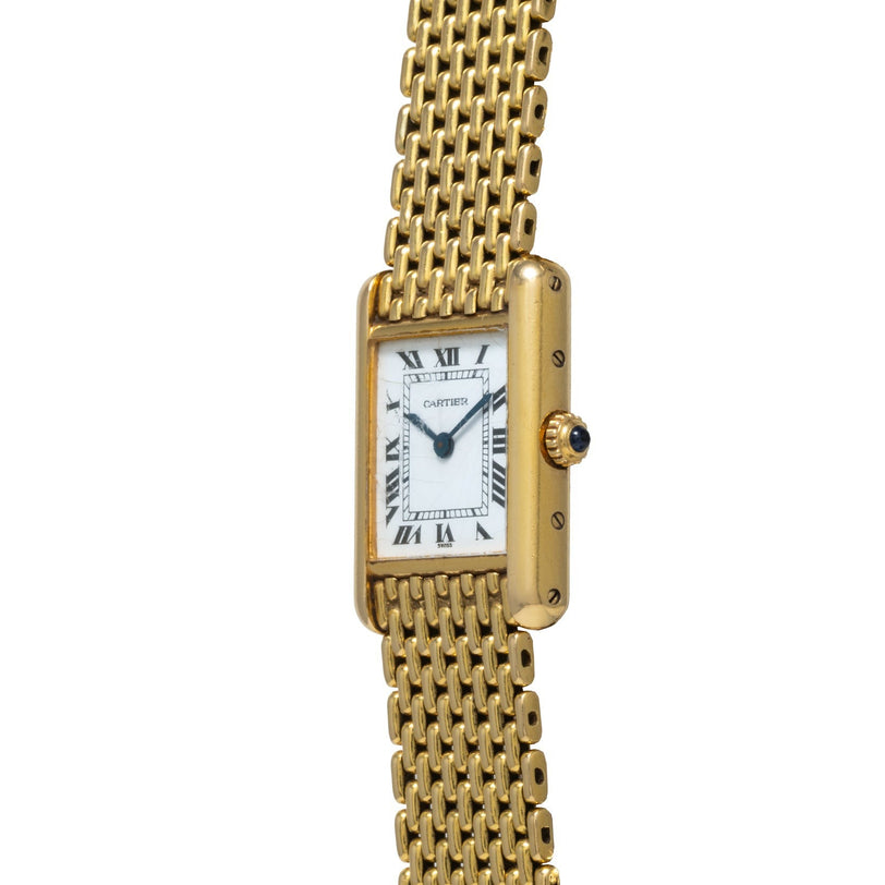 Cartier Tank Louis gold wristwatch featuring a rectangular face, Roman numerals, and a mesh bracelet shown upright.