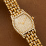 Cartier Tortue Diamond watch featuring a diamond-studded face and bracelet, displayed on a brown leather surface.
