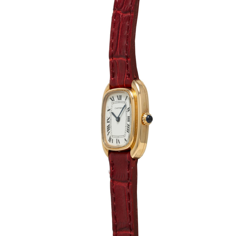 The Cartier Gondole Ladies watch features a gold rectangular case, white dial with Roman numerals, and a red leather strap, displayed at an angle.