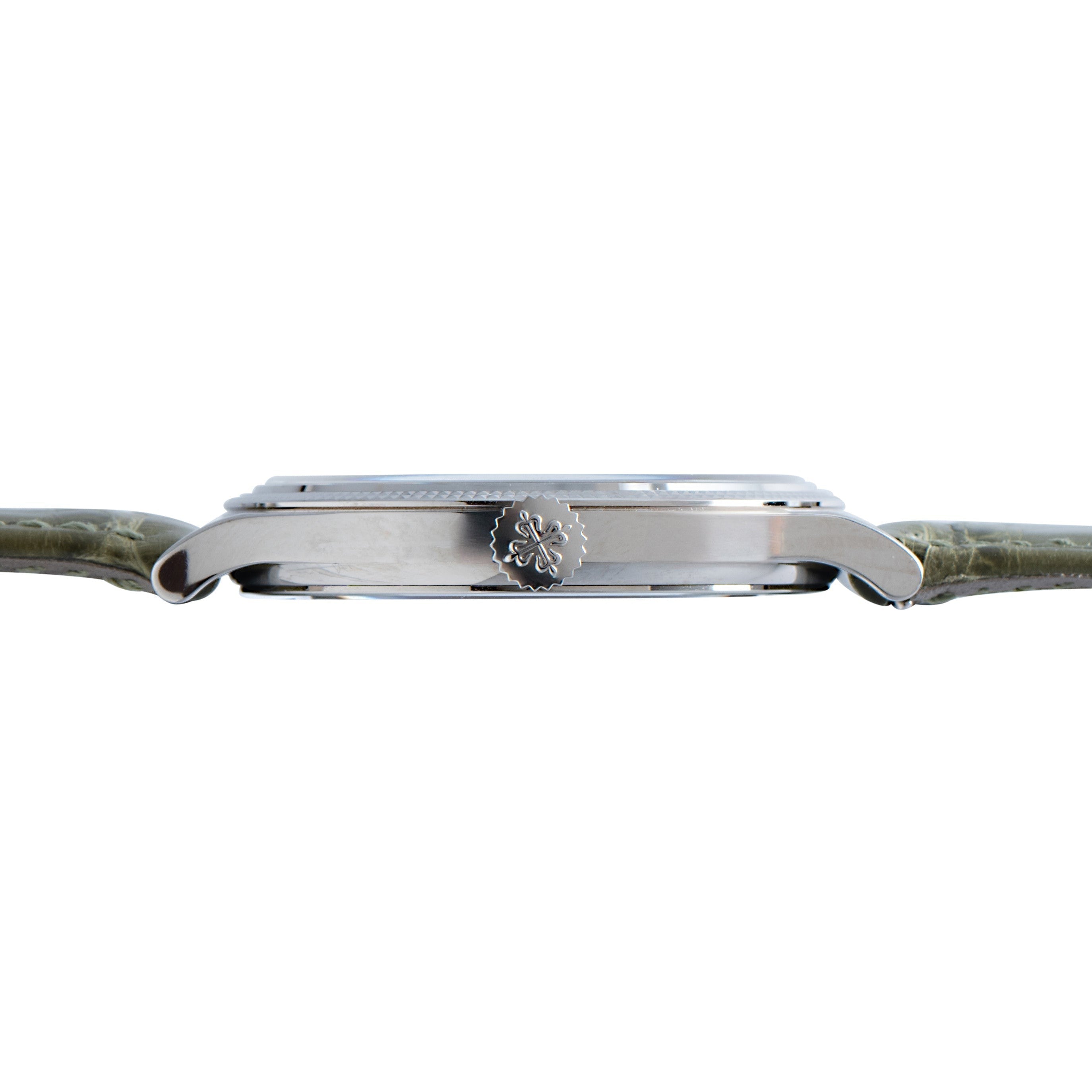 Side view of the Patek Philippe Calatrava Cloisonné Tropical Leaves II, a silver wristwatch with a green leather strap and decorative crown on the right side.