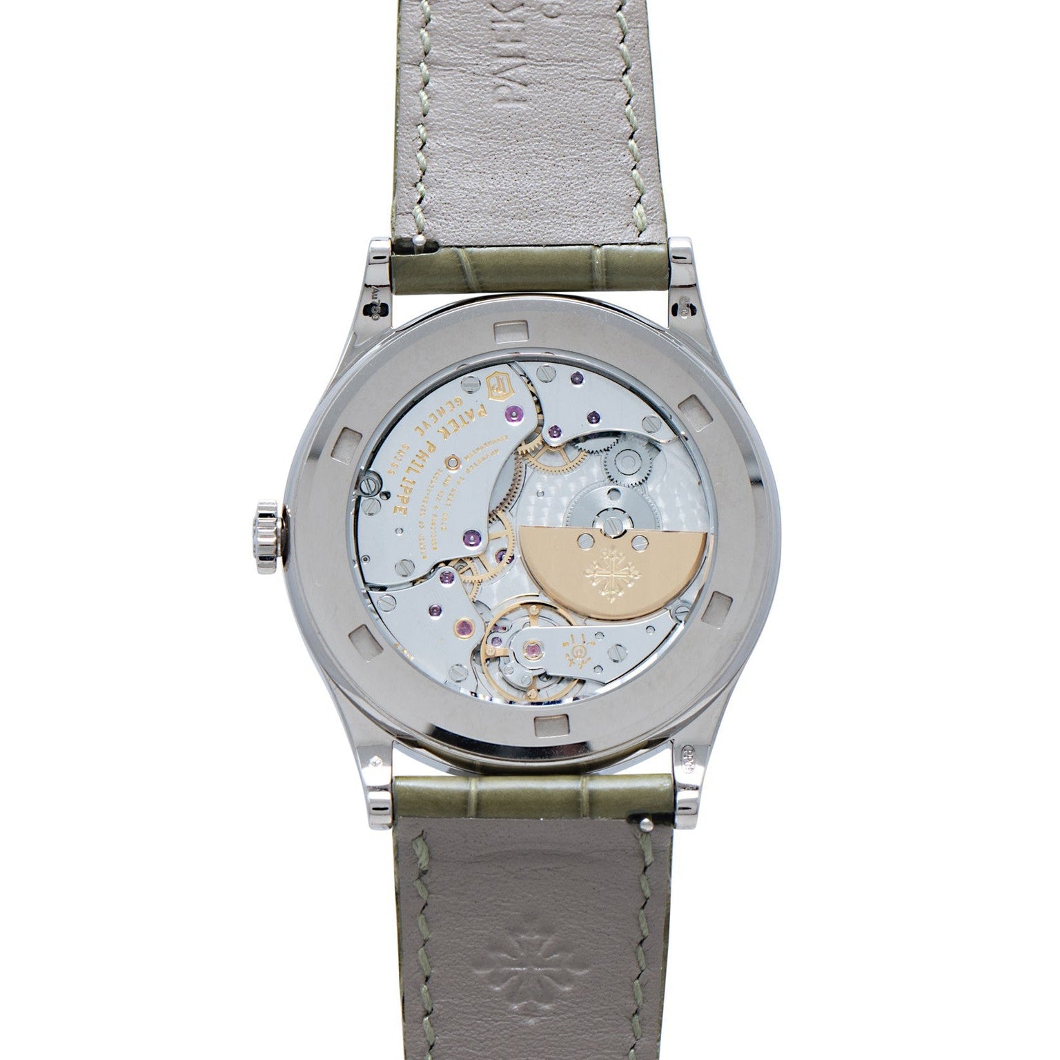 Patek Philippe Calatrava Cloisonné Tropical Leaves II wristwatch features an open case back displaying its intricate mechanical movement and a leather strap.