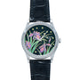 The Patek Philippe Calatrava Cloisonné Iris & Night Fireflies is a silver watch with a black leather strap and a dial adorned with purple irises and green leaves on a dark background.