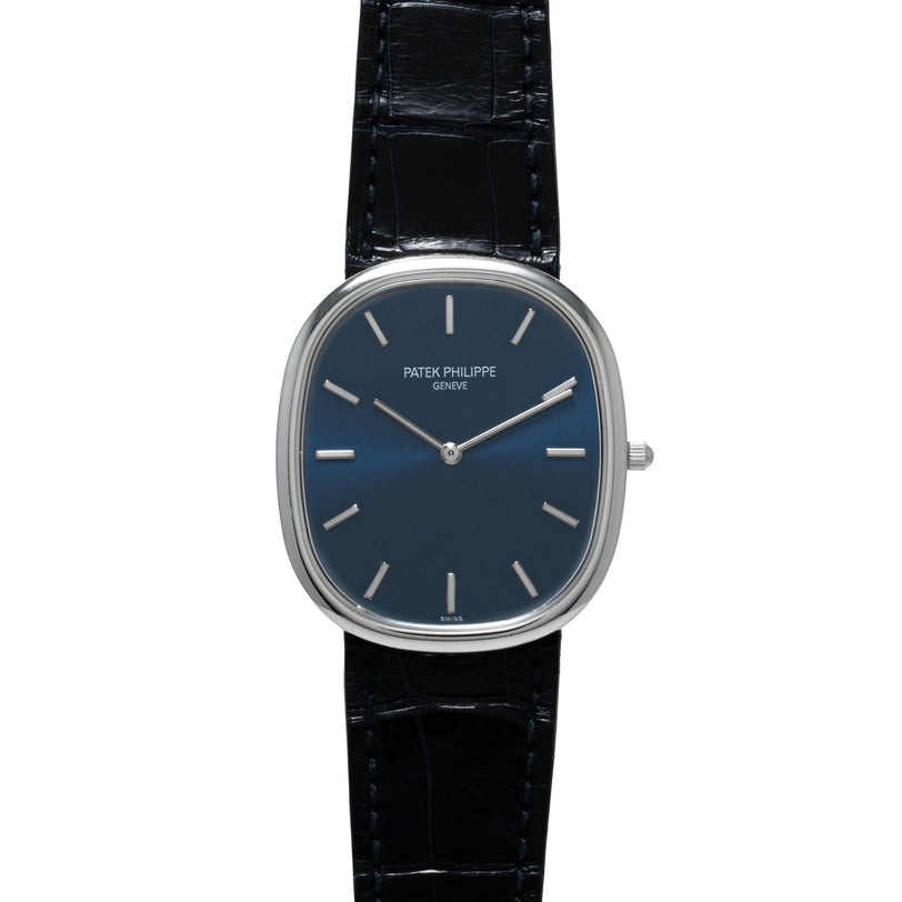 A Patek Philippe Ellipse Jumbo watch with a blue dial, silver markers, and a black leather strap is shown face up.