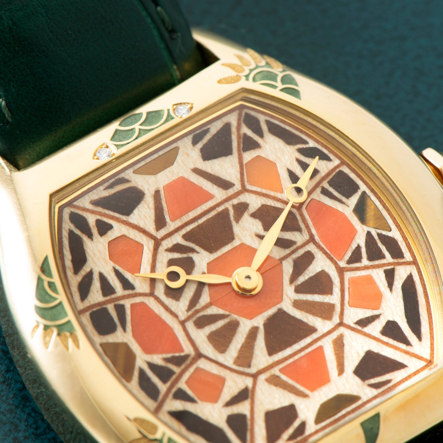 The Cartier Tortue XL Turtle Limited Edition features a mosaic-patterned face, green strap, and decorative enamel details, displayed on a dark textured surface.