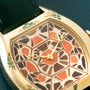 The Cartier Tortue XL Turtle Limited Edition features a mosaic-patterned face, green strap, and decorative enamel details, displayed on a dark textured surface.