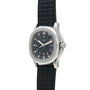 A Patek Philippe Aquanaut wristwatch featuring a silver case, black dial, and black textured rubber strap.