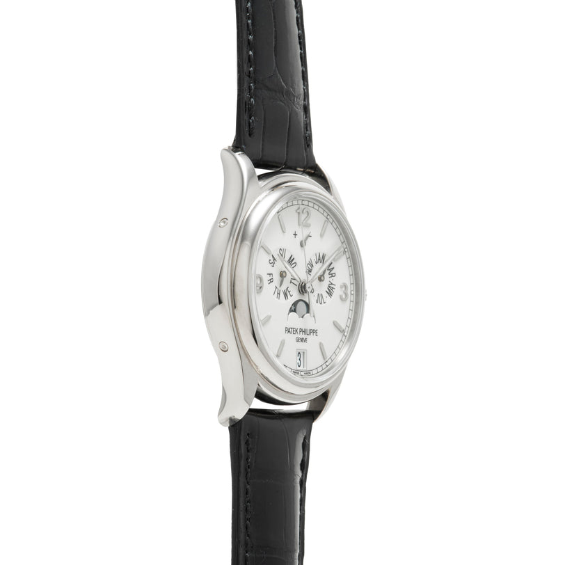 Side view of a Patek Philippe Annual Calendar Moonphase wristwatch featuring a silver case, white dial, black leather strap, multiple subdials for the annual calendar, moon phase display, and date window.