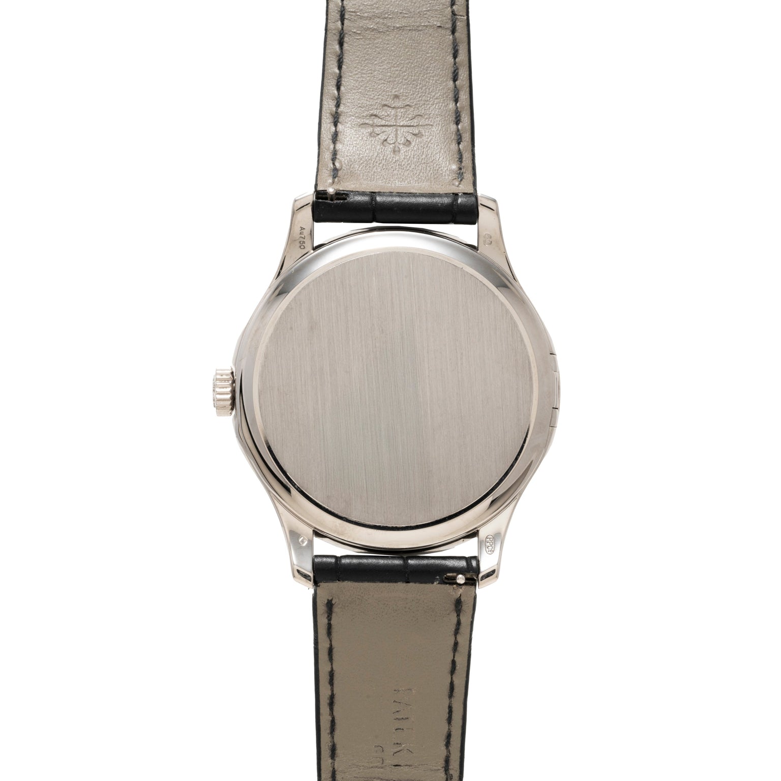 The back of a Patek Philippe Calatrava silver wristwatch with a black leather strap, showing a plain metal case back.