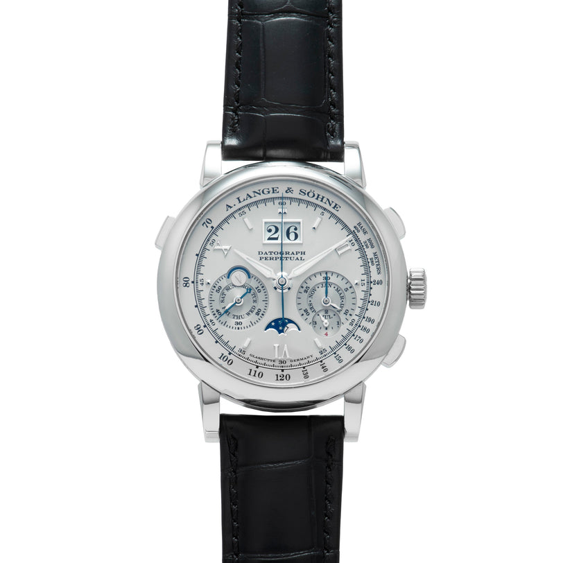 The Lange & Sohne Datograph Perpetual Calendar is a silver wristwatch with a black leather strap, multiple subdials, moon phase, and large date display.