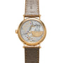 The Patek Philippe Calatrava wristwatch features an exposed mechanical movement and leather strap, viewed from the back.