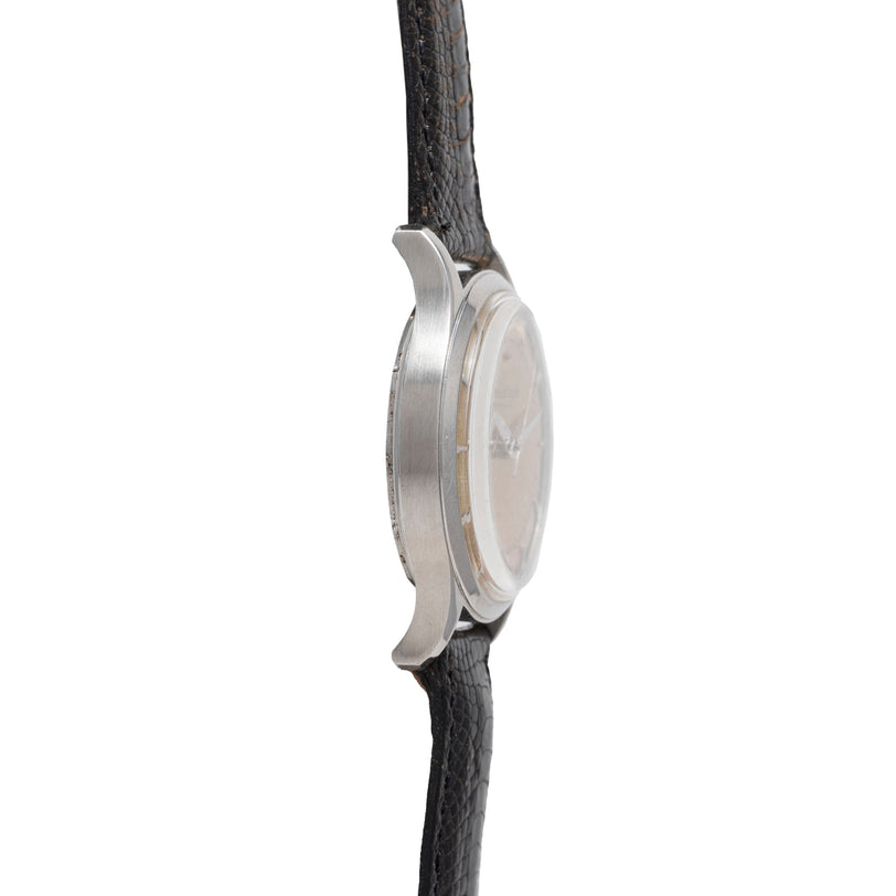 Side view of a Jaeger LeCoultre 'European Market' Powermatic dress watch, showing the round silver case and textured black leather strap, with focus on the case thickness and lugs; the watch face is not visible.