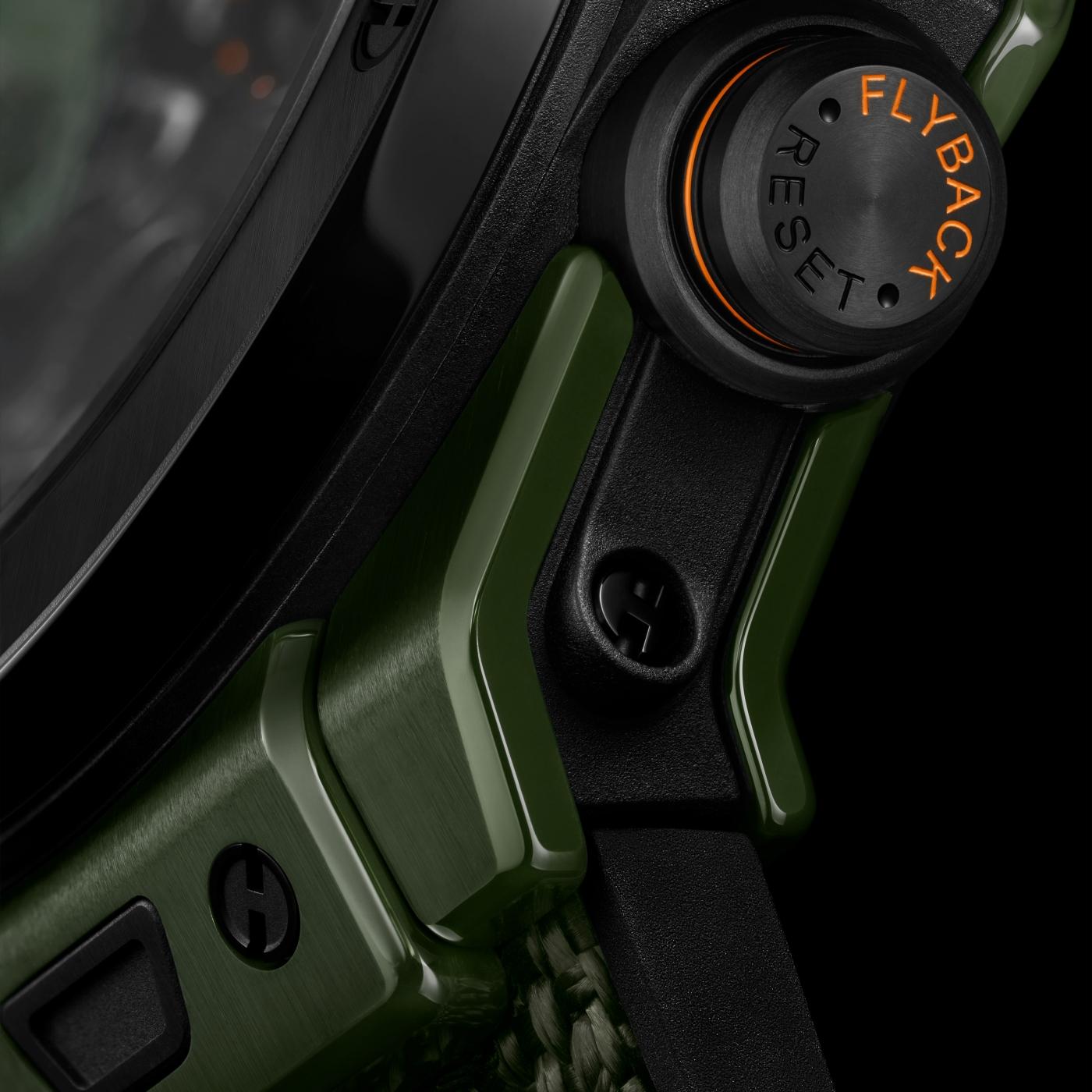 Dark green ceramic watch with black rubber strap and orange accent dial featuring Flyback reset function.