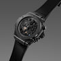 All-black chronograph watch with skeleton dial showing exposed movement, textured rubber strap, and side pusher buttons.