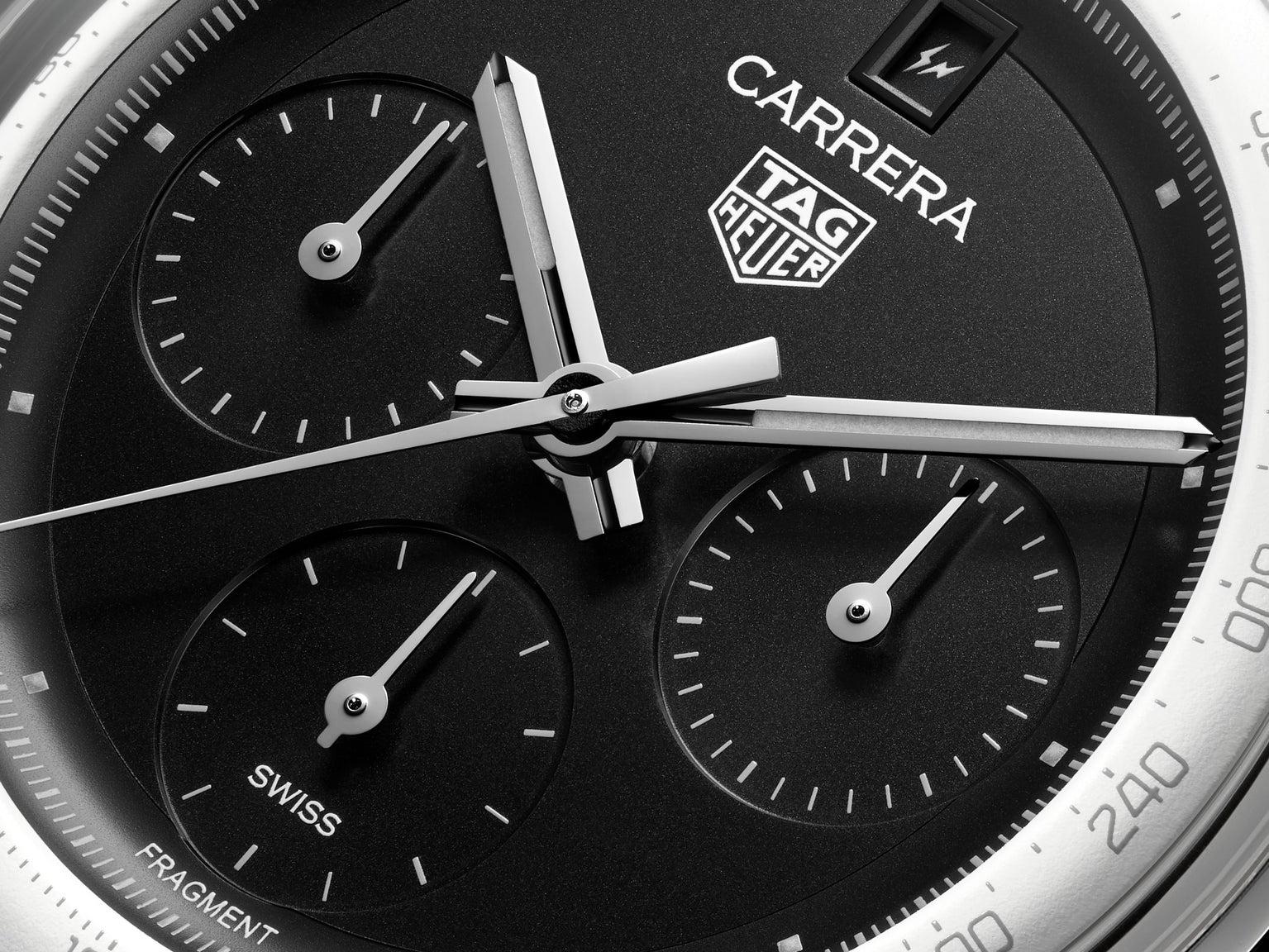 Close-up of the TAG Heuer Carrera Chronograph x Fragment Limited Edition watch face, featuring three subdials, bold white hands, and the TAG Heuer logo on a black background with a tachymeter scale around the edge.
